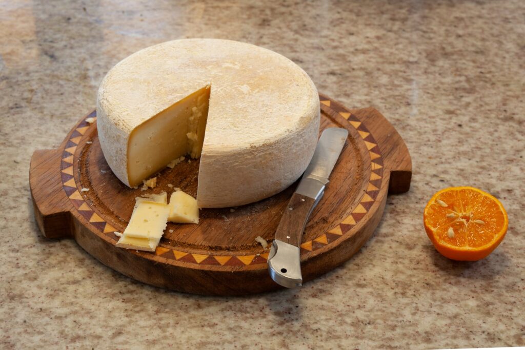 a cheese board with a piece of cheese on top of it